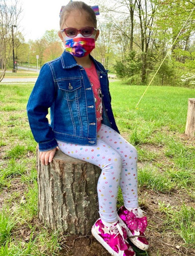 Six year-old Daniella sitting on a tree stump