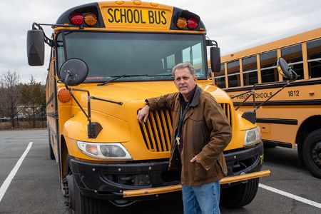Jay Corwin stands with a school bus