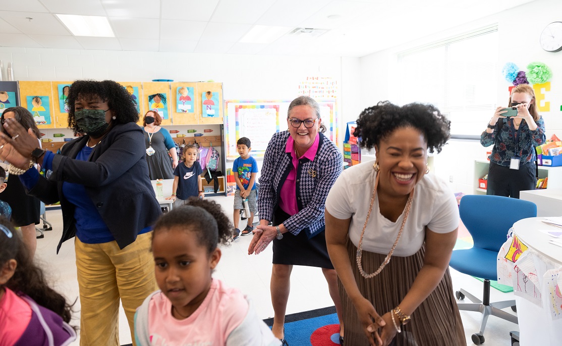 Dr. Reid dances with children in a classroom during a movement break. 