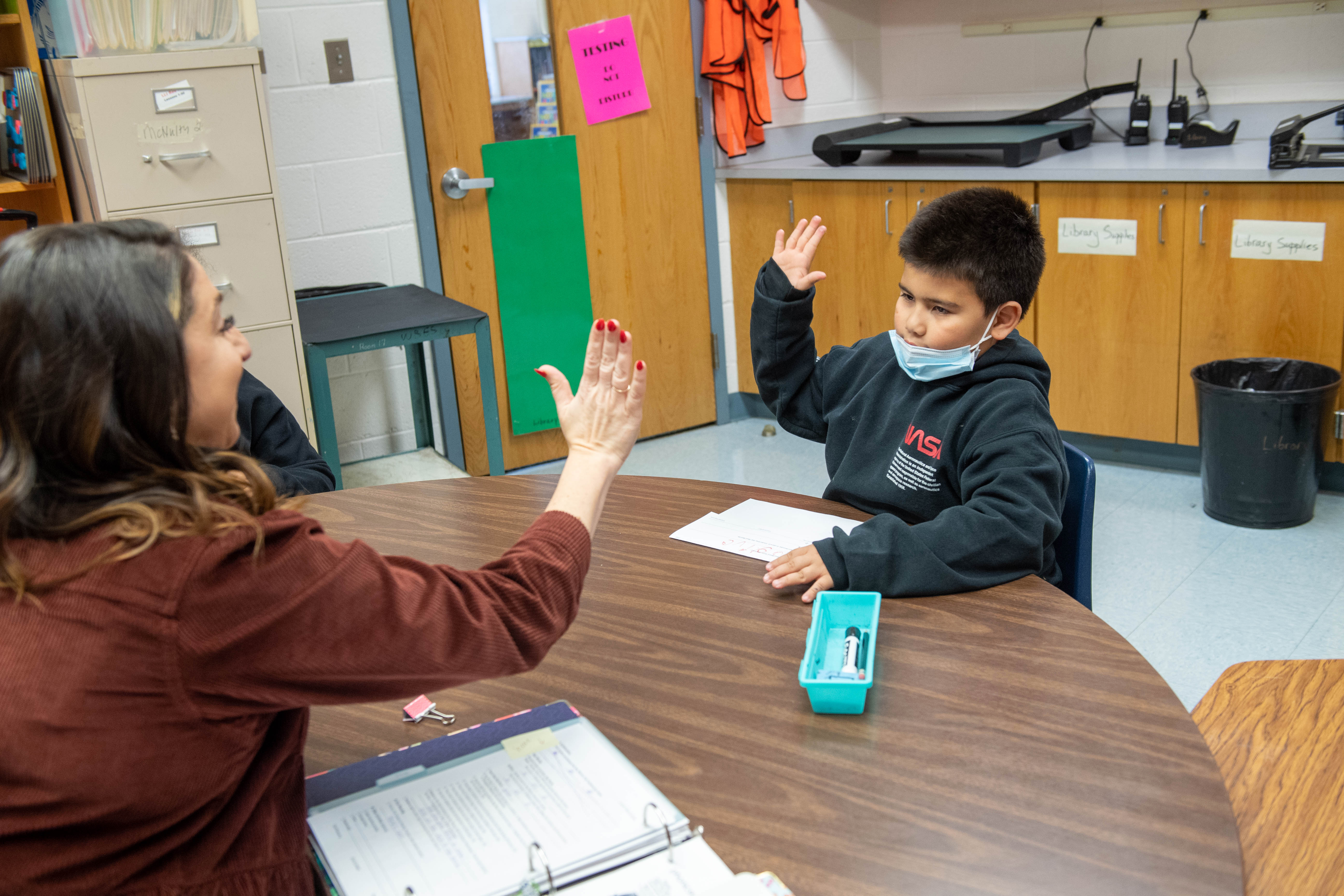 Reading interventionist Johnston high-fives Justin, a third-grader she works with who has made two years of academic progress in one year of work.