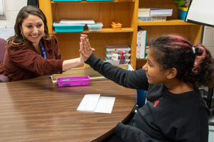 teacher giving high five to student