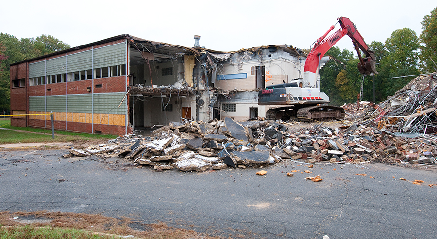Photograph showing a backhoe demolishing part of the former Masonville Elementary School.
