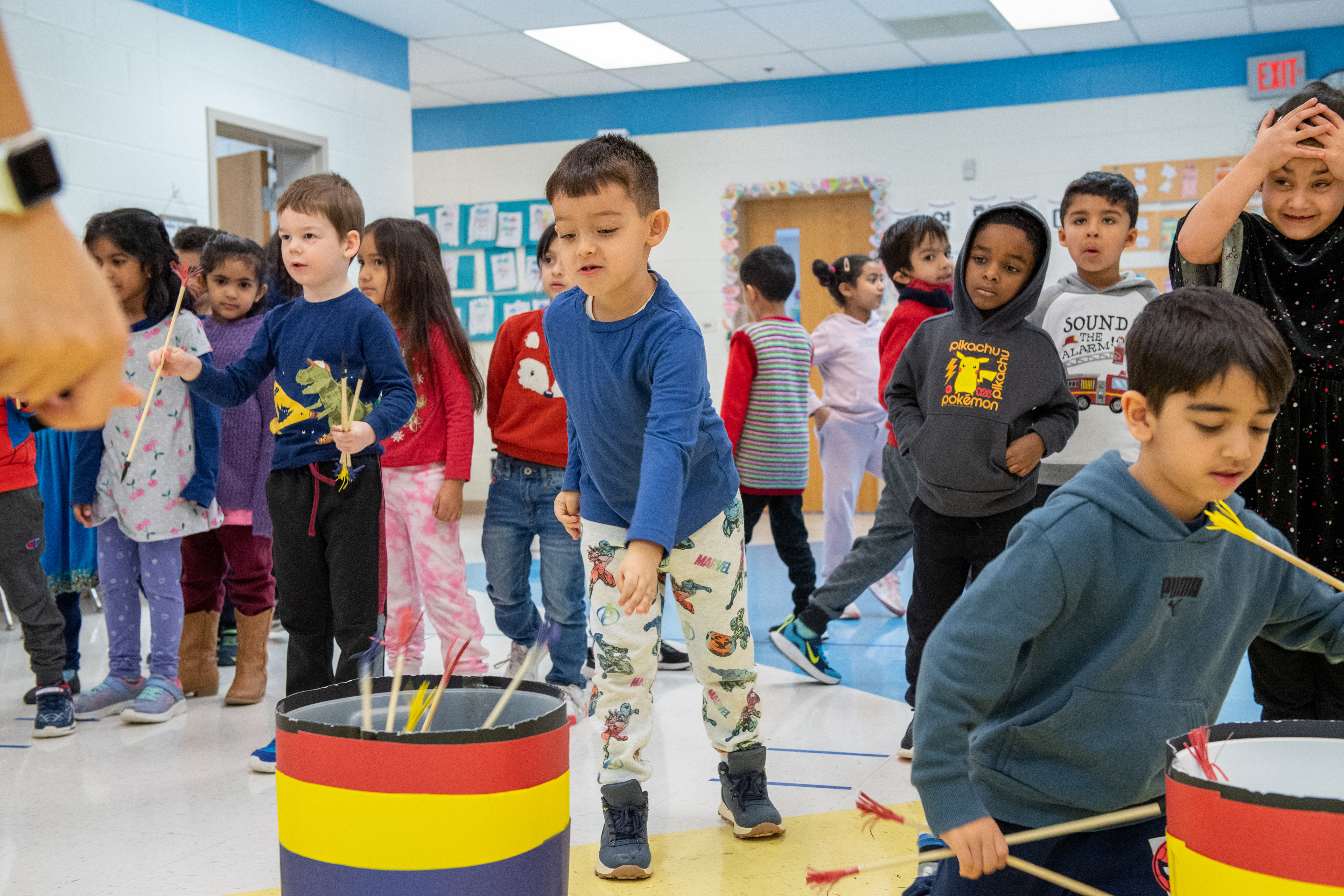 Kindergarten students play a game of throwing sticks into barrels as part of Lunar New Year festivities.