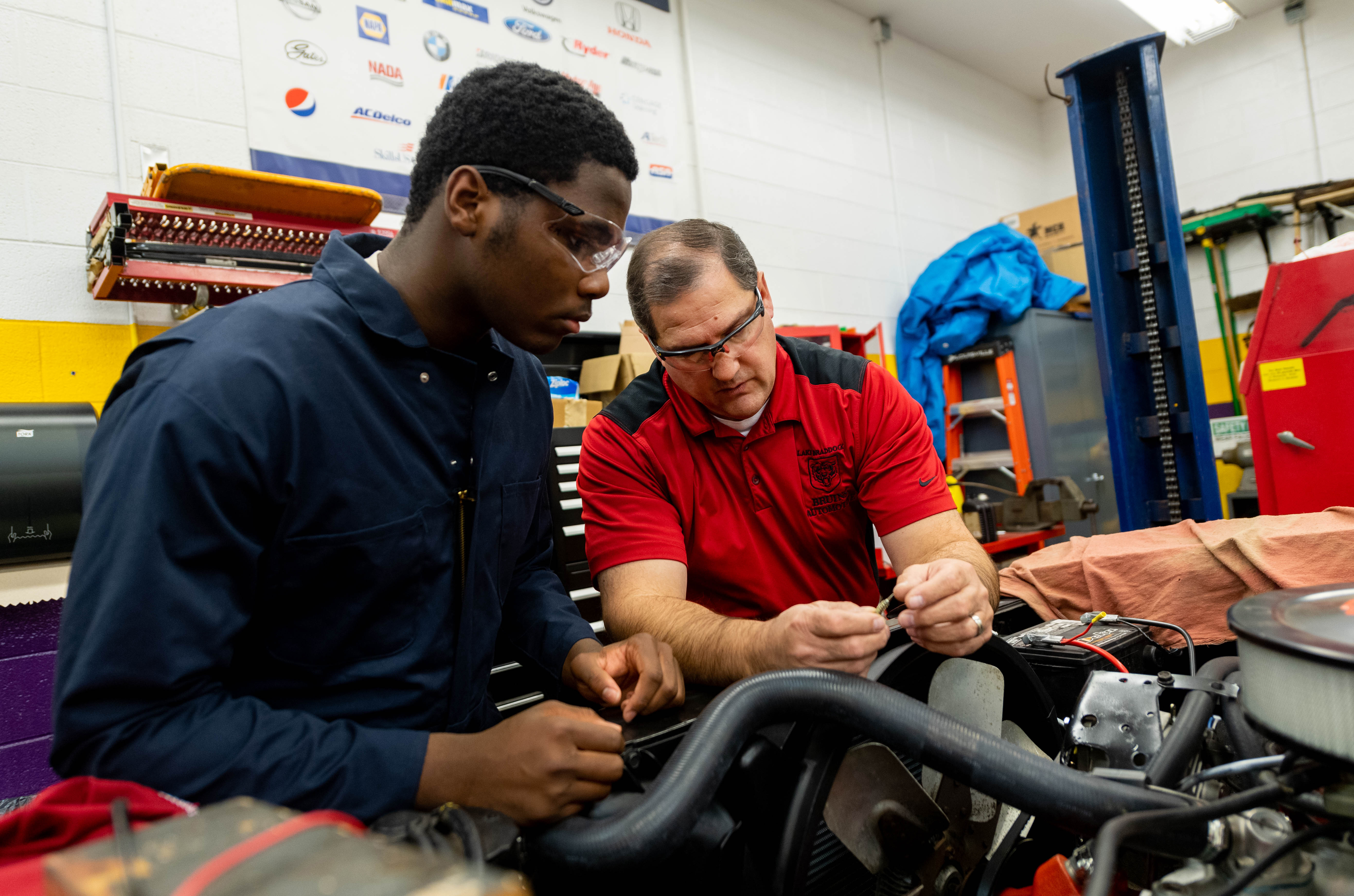 Prakash, who has helped lead the Lake Braddock Secondary auto shop for 23 years, works with a student.