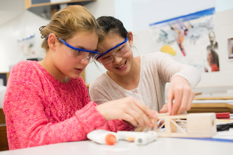 photo of two young students working on a project