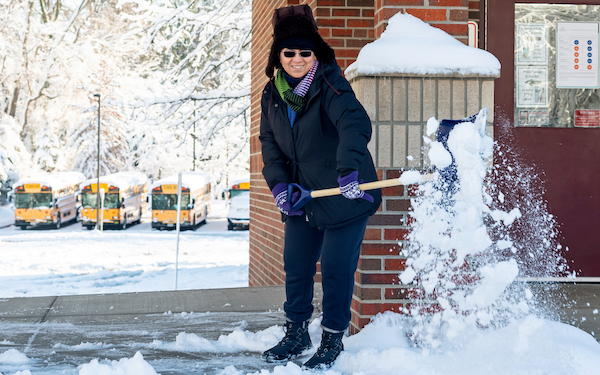 A staff person shovels snow