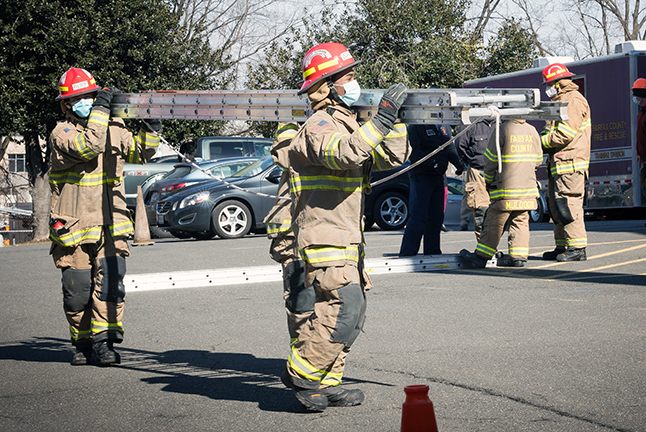 students in the firefighting class at Chantilly Academy holding a ladder