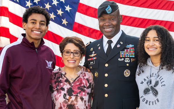 A military family in front of a flag