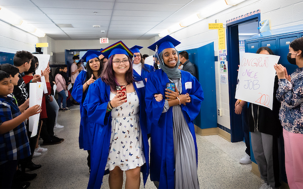 Graduates walk down a hallway
