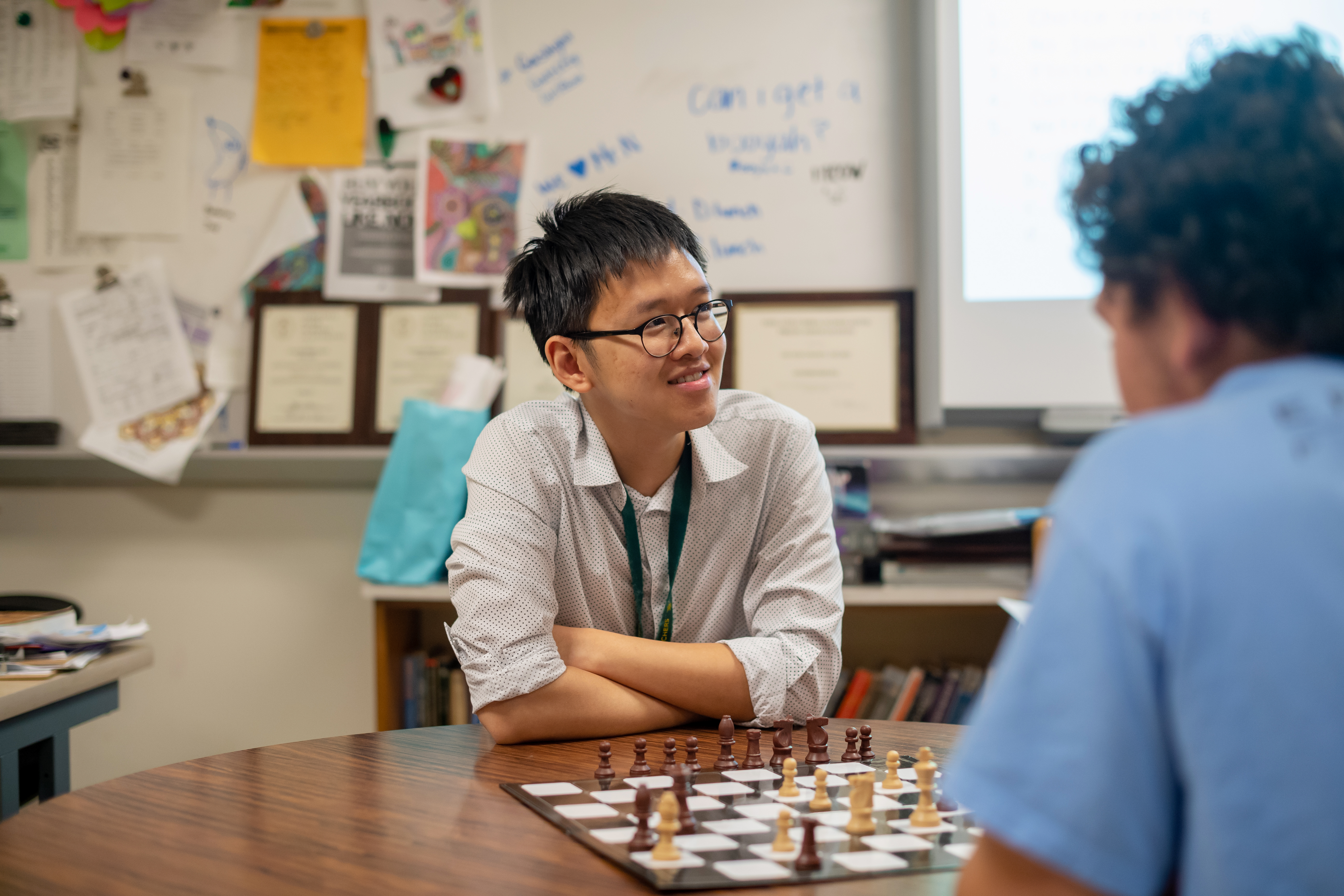 Luc Nguyen place chess with a student