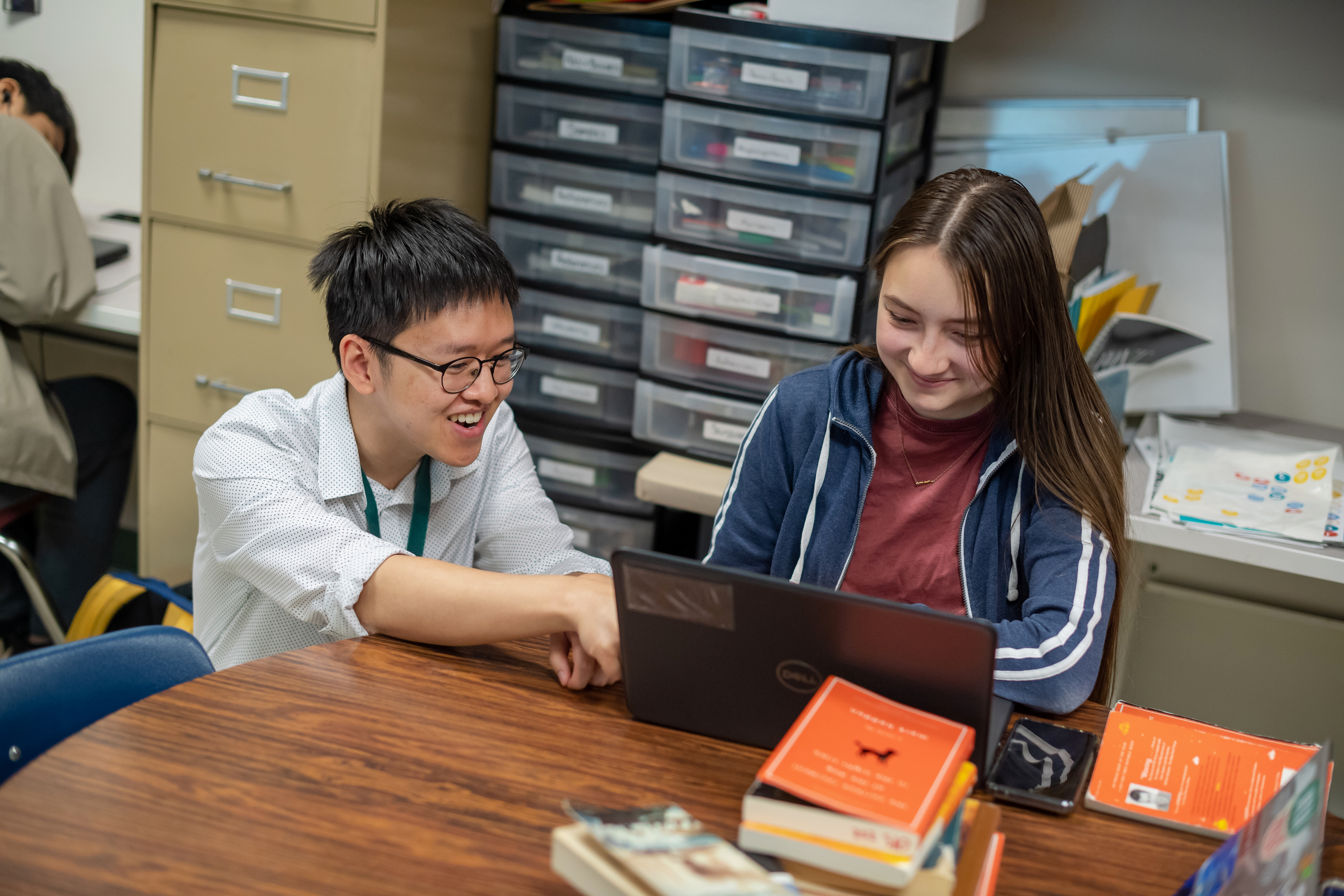 Nguyen assists a student on a laptop