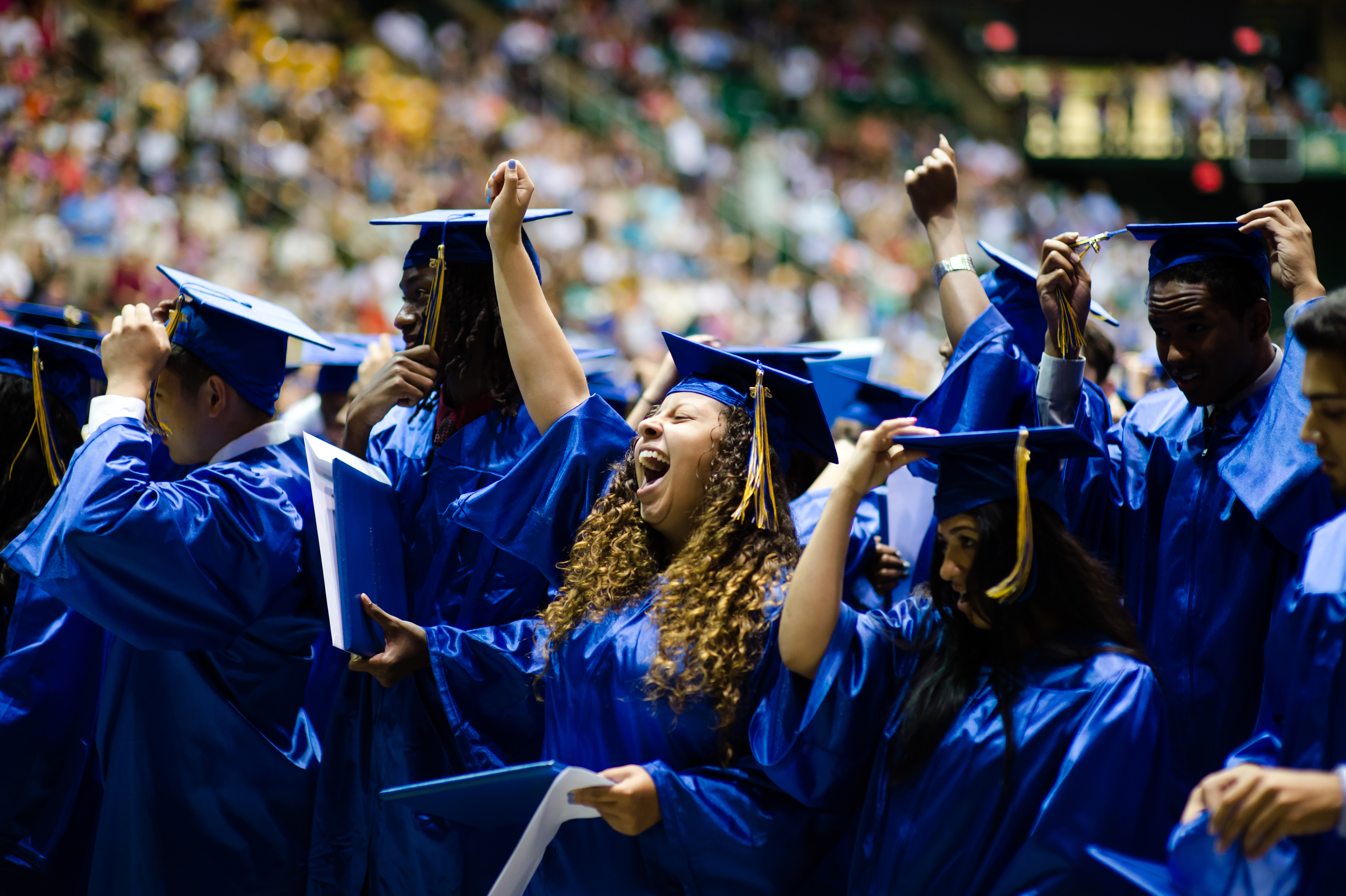Group of students at graduation wearing blue robes.  