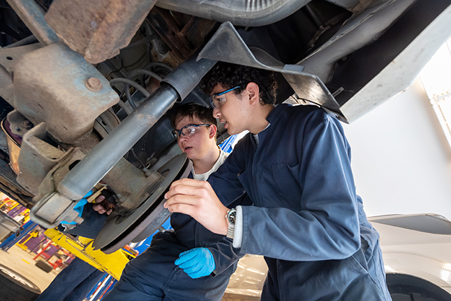 auto tech students working on a car together