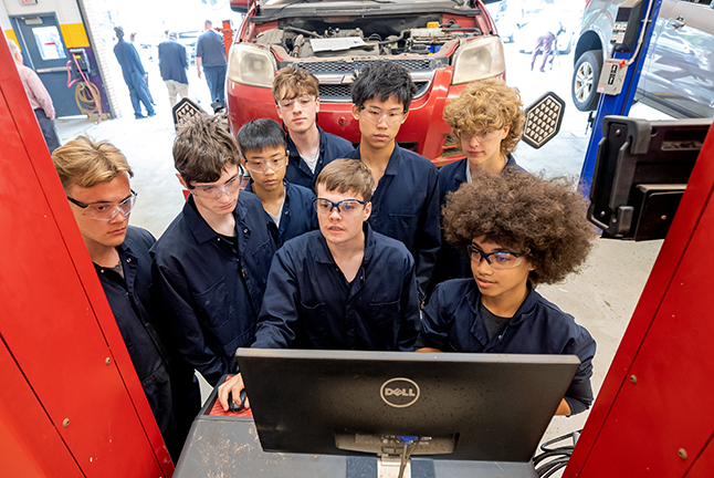 auto tech students looking at a car diagnostics machine screen