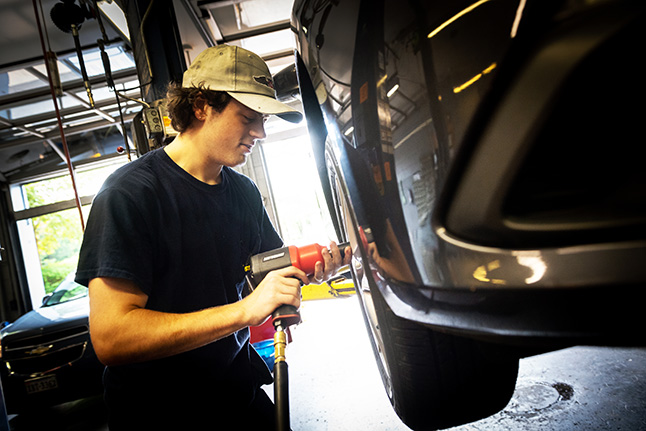 student working on a car tire
