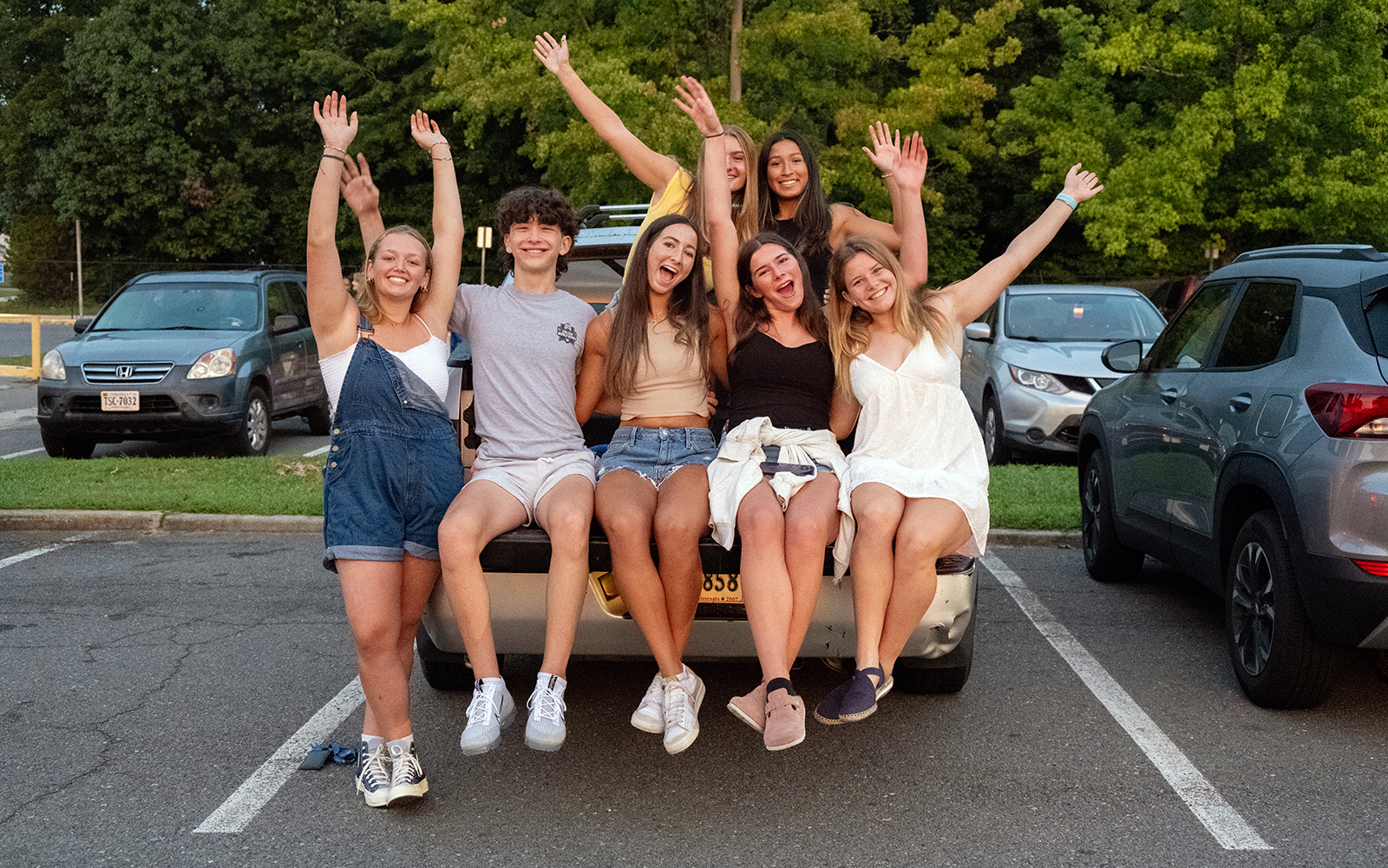 Happy students cheer in a parking lot