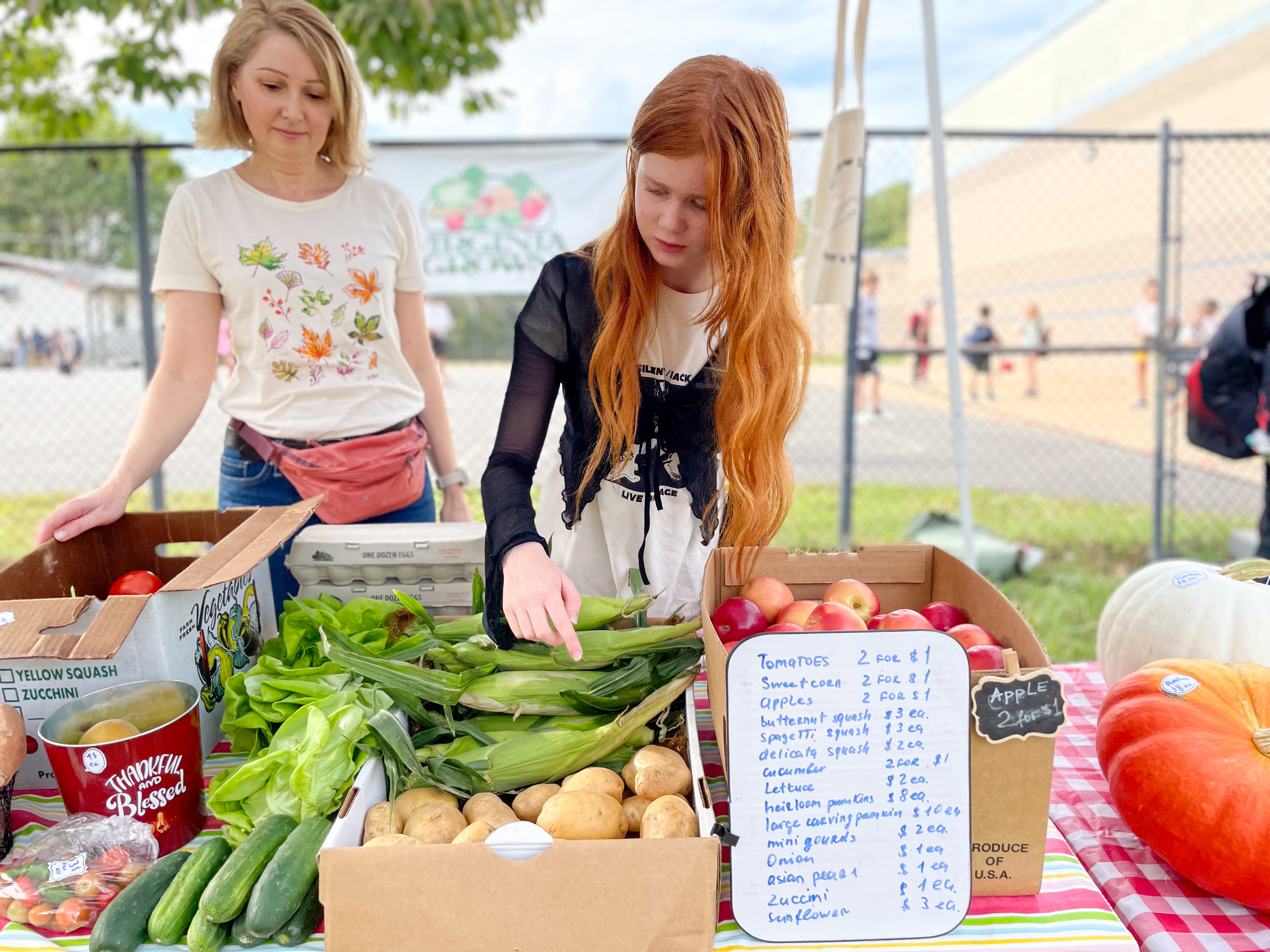 Willow Springs sixth grader, Arina, and mother, Yulia, prepare to open the school's farmers market.