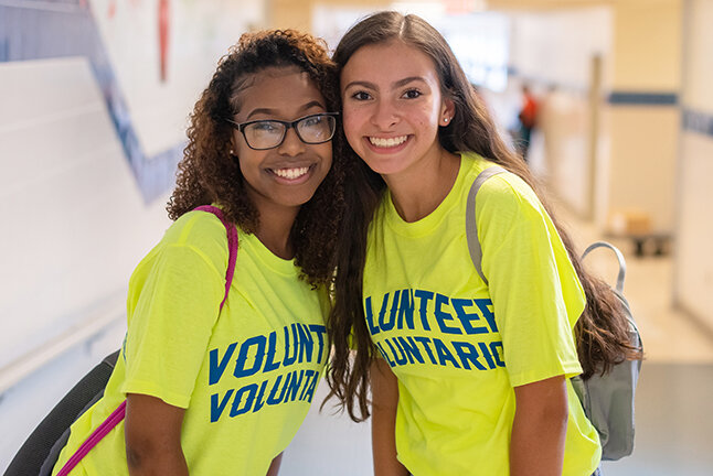 two volunteers standing together