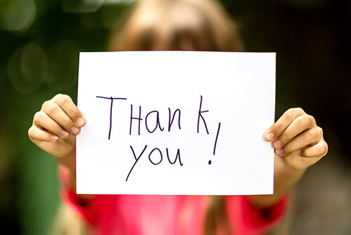 student holding a thank you sign