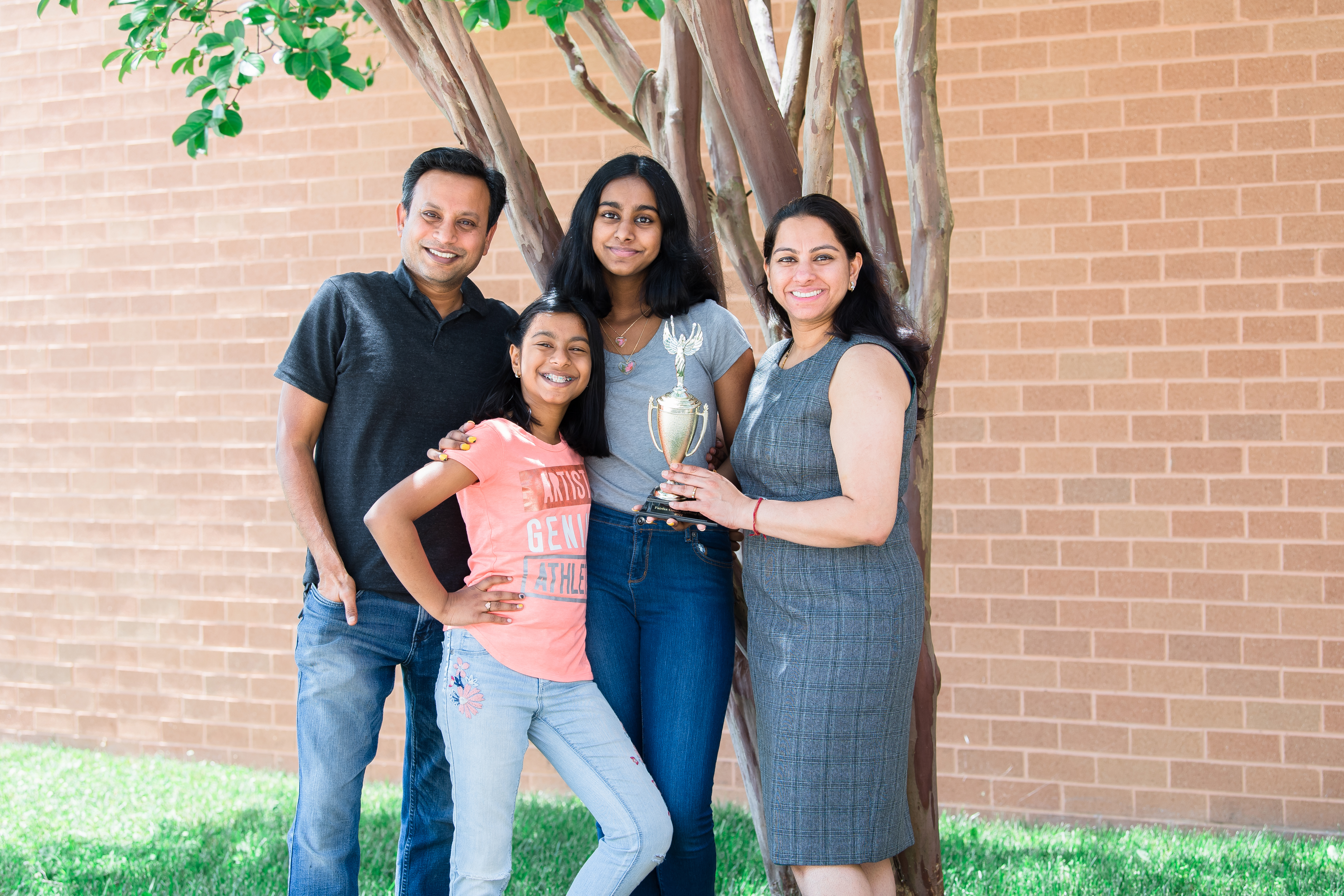 Akshita poses with her parents, younger sister and a spelling trophy
