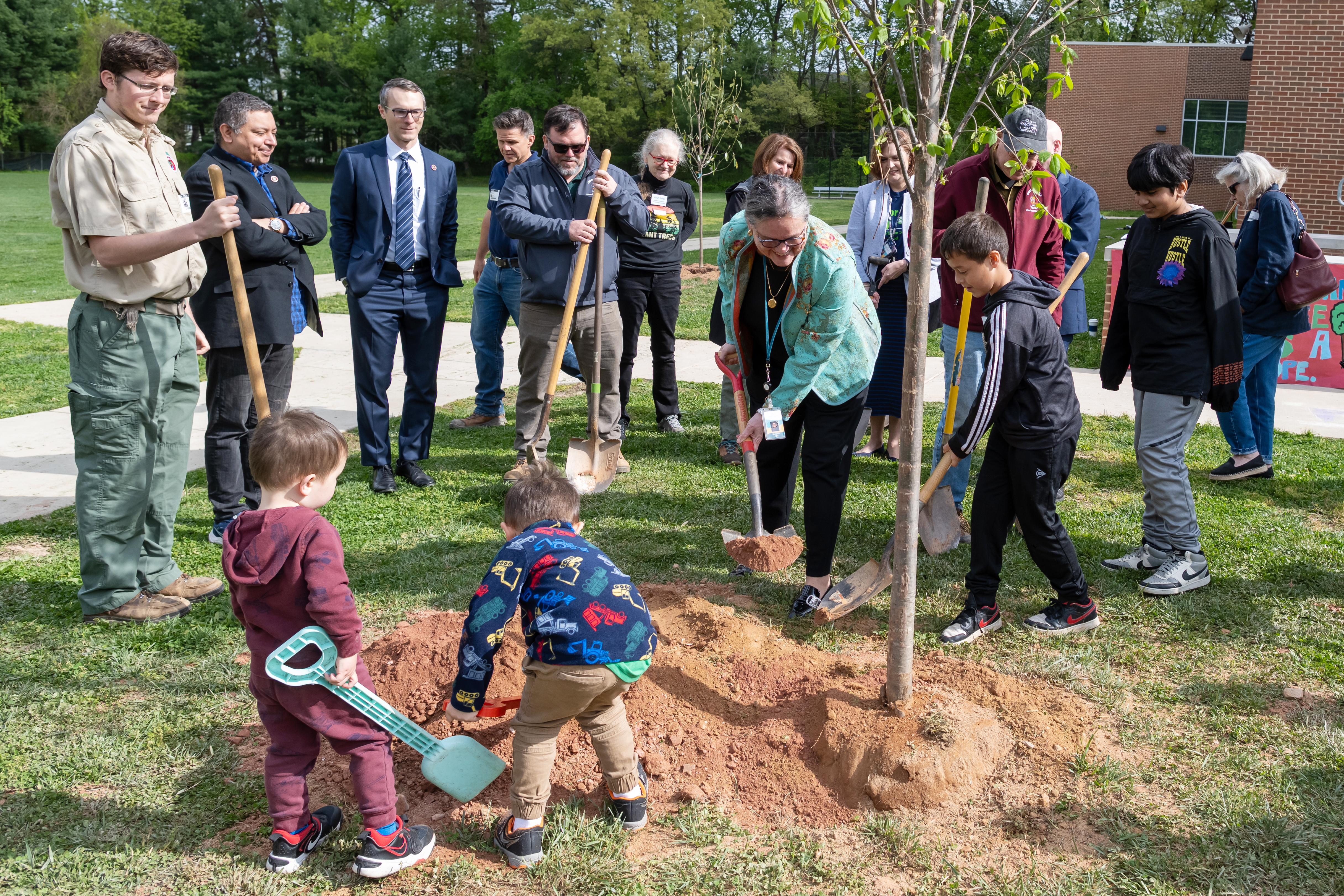 Dr. Reid helps students plant trees at an Annandale Terrace ES Arbor Day celebration