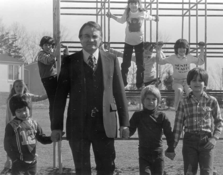 Black and white photograph of Principal Freeman with students.