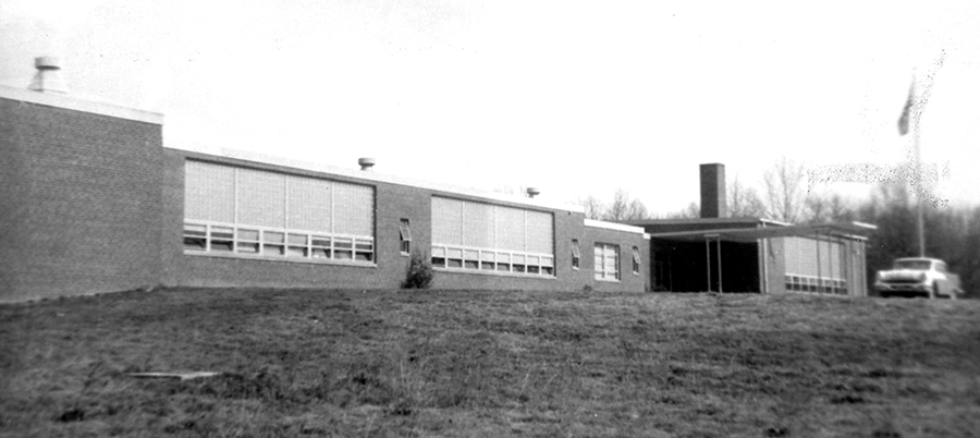 Photograph of the front exterior of Clifton Elementary School taken around 1958. A car is parked in front of the building.