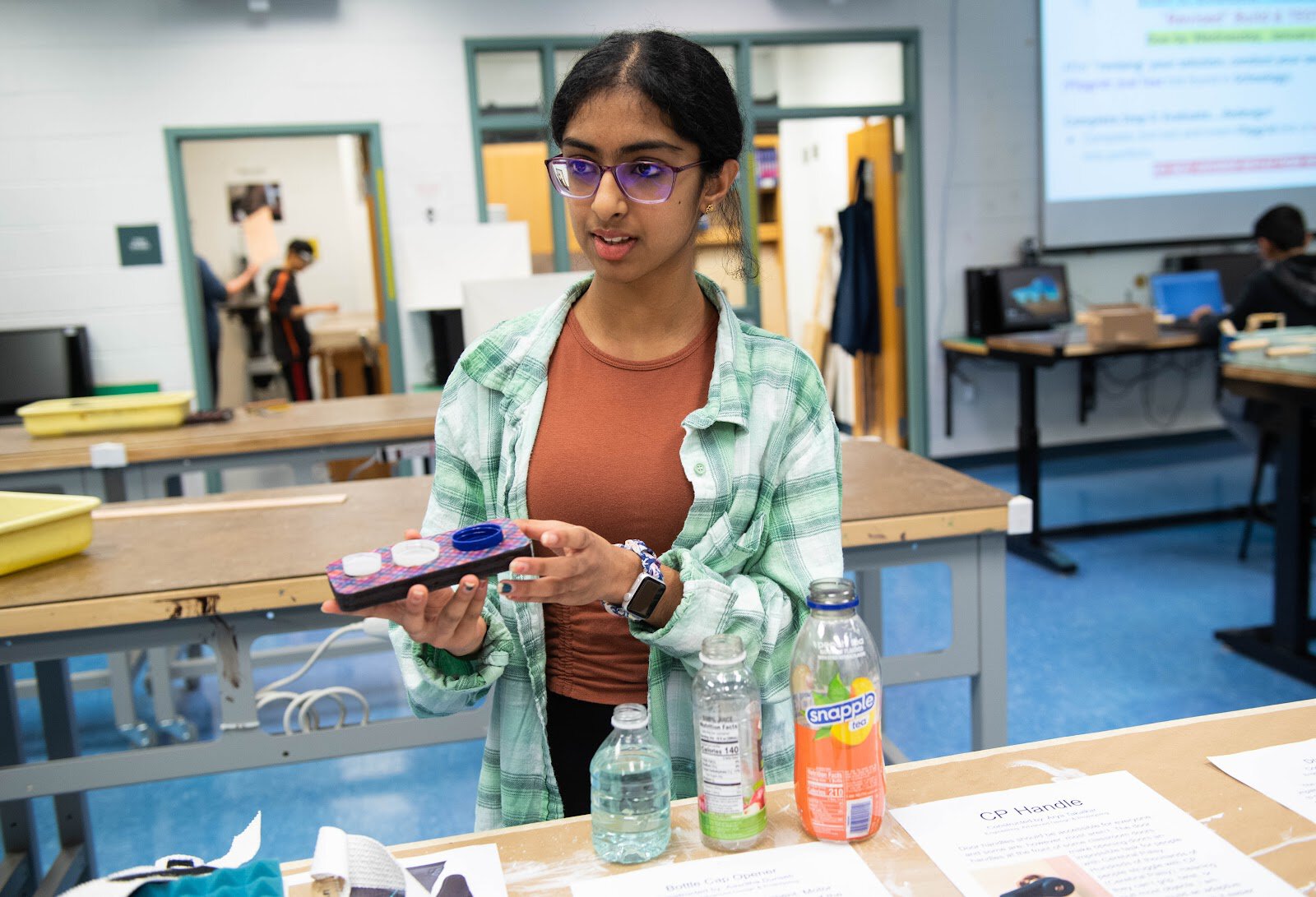 An Engineering 3 student at Rachel Carson MS displays a bottle opener device designed with her grandmother in mind.