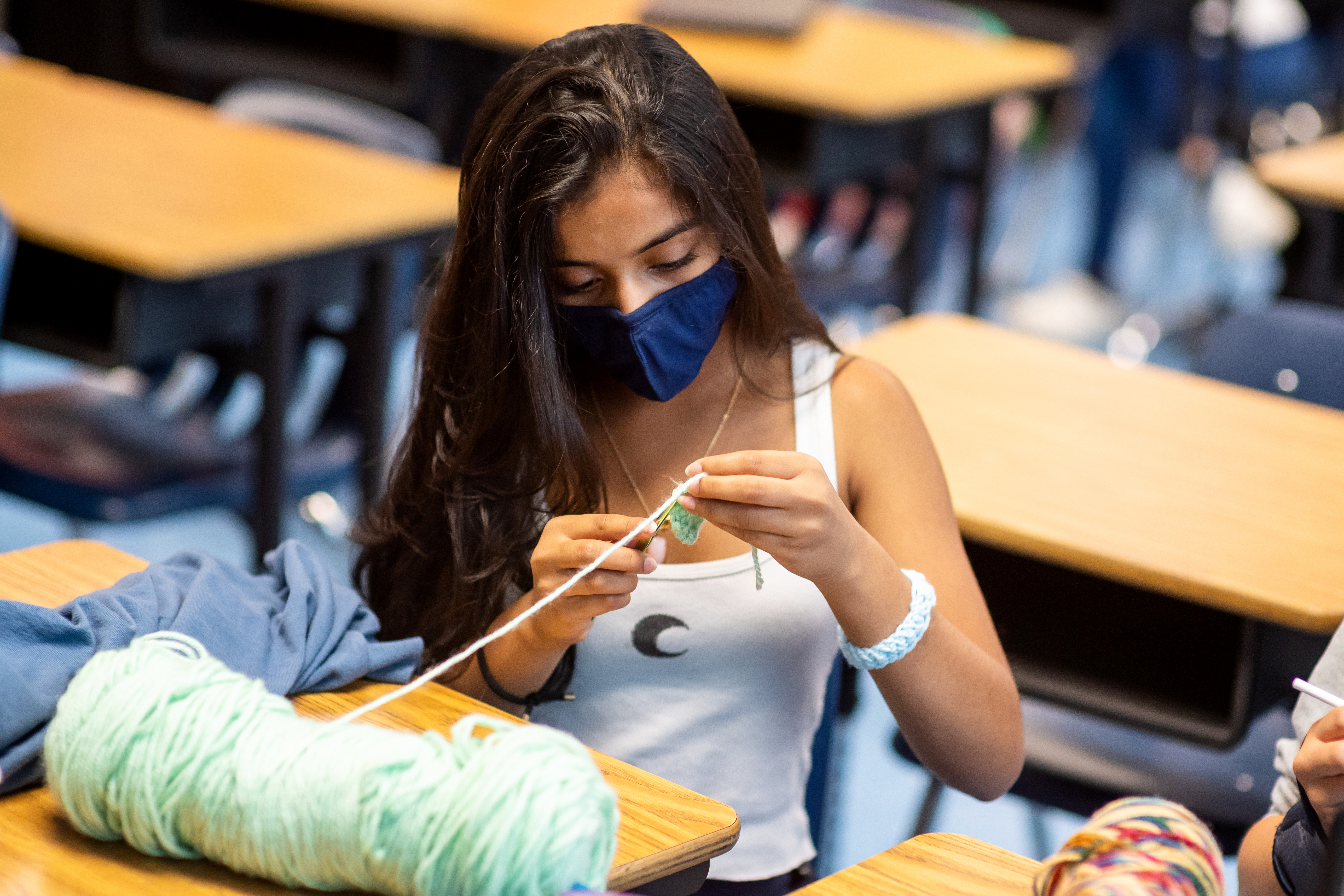 A Katherine Johnson middle school student is learning to knit as part of a social-emotional learning time period intended to help students build relationships with staff and pursue enrichment activities.