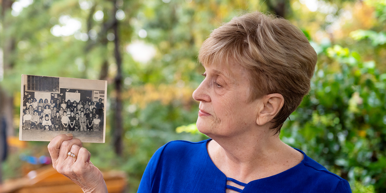 Gail Adams Batt, an FCPS graduate who was part of the district's leading role in the Salk polio vaccine field trials in 1954, looks at class pictures from her time as a "Polio Pioneer."