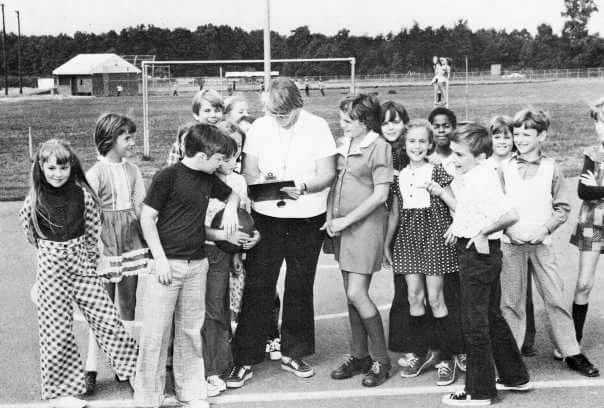 Black and white photograph of a group of students on the playground.