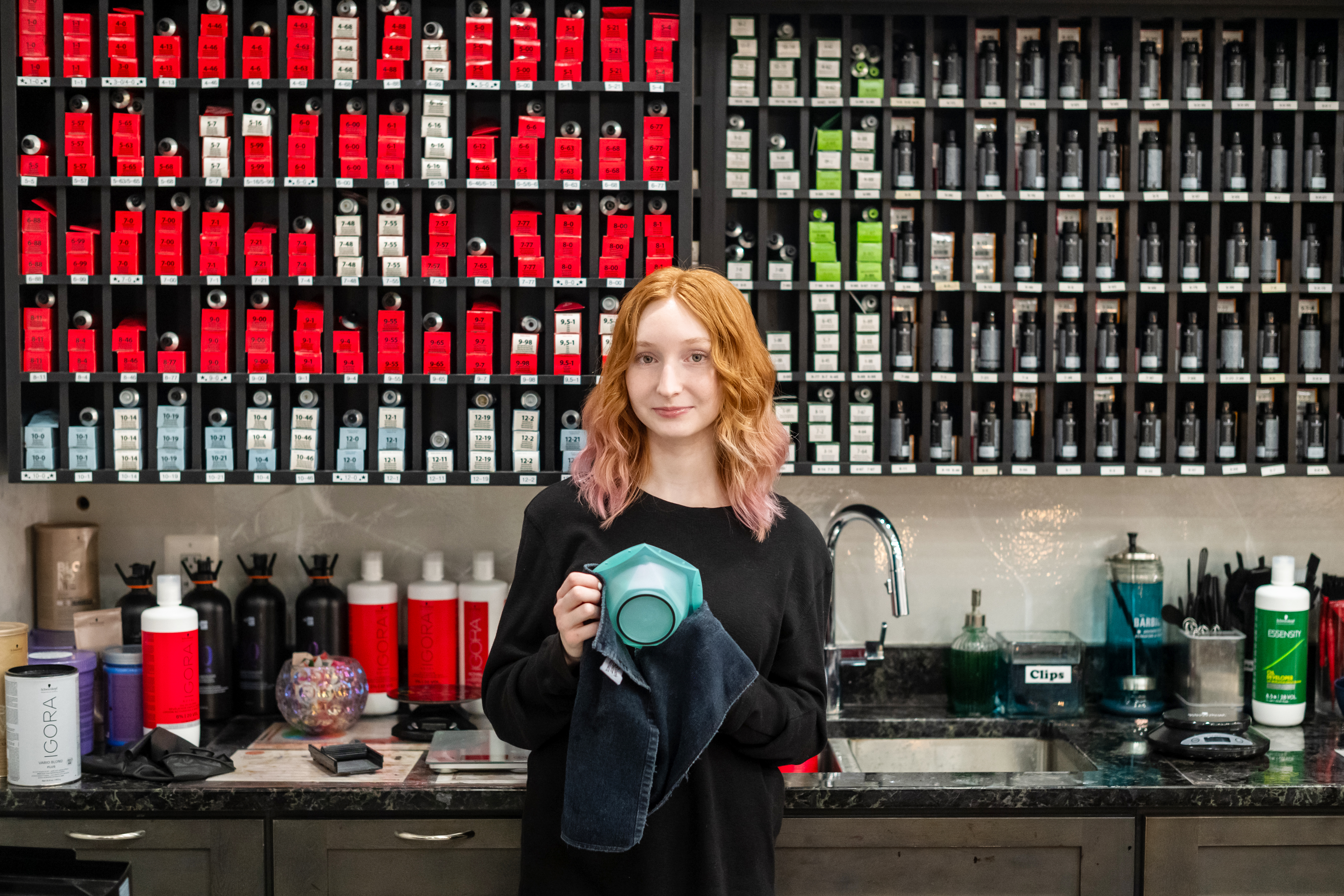 A Cedar Lane student interning at Arya Salon in Vienna stands in front of the hair color bar during her internship.