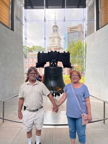 A couple stands before the liberty bell