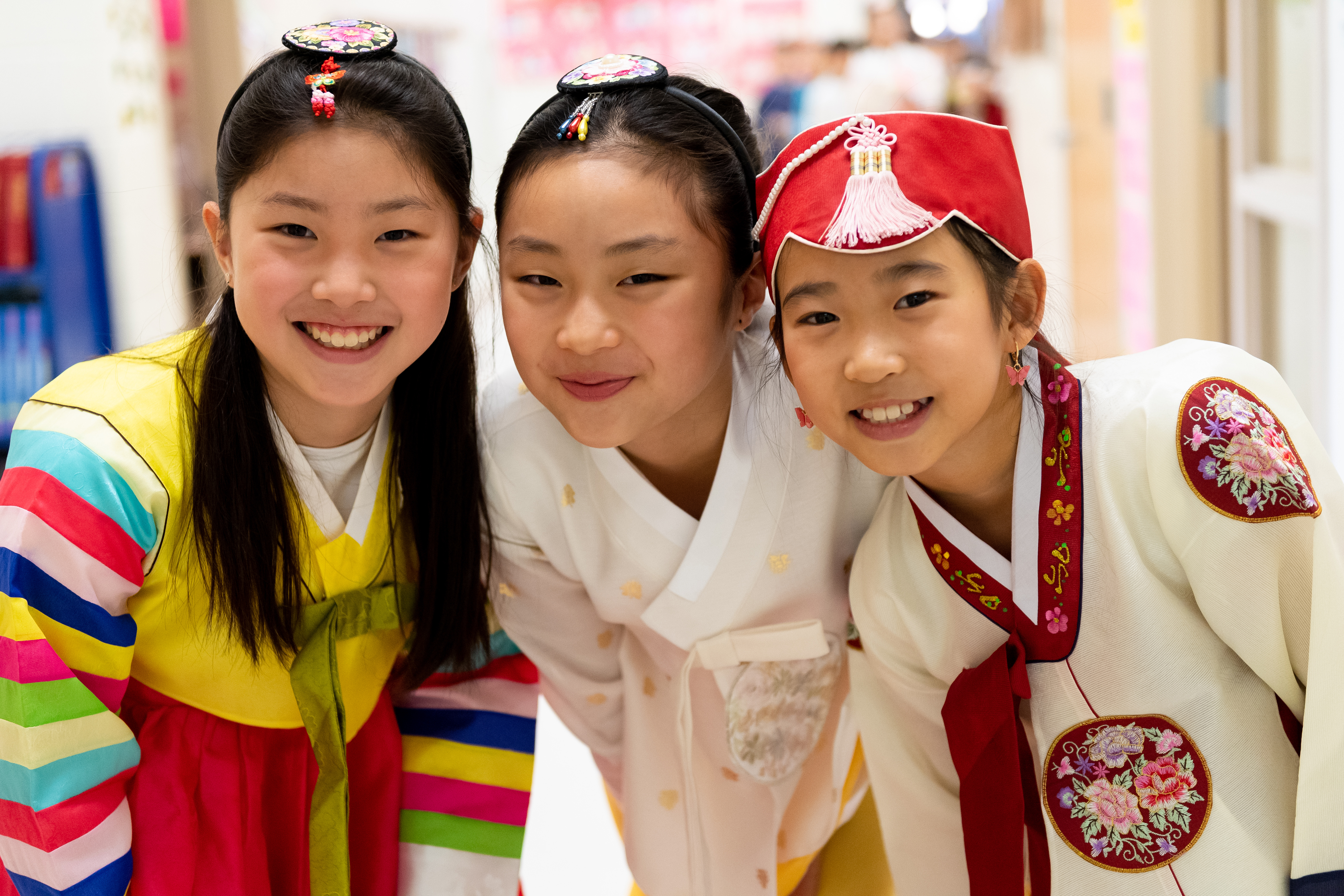 Three Powell Elementary students wear hanboks, or traditional Korean dresses, to celebrate to Lunar New Year.