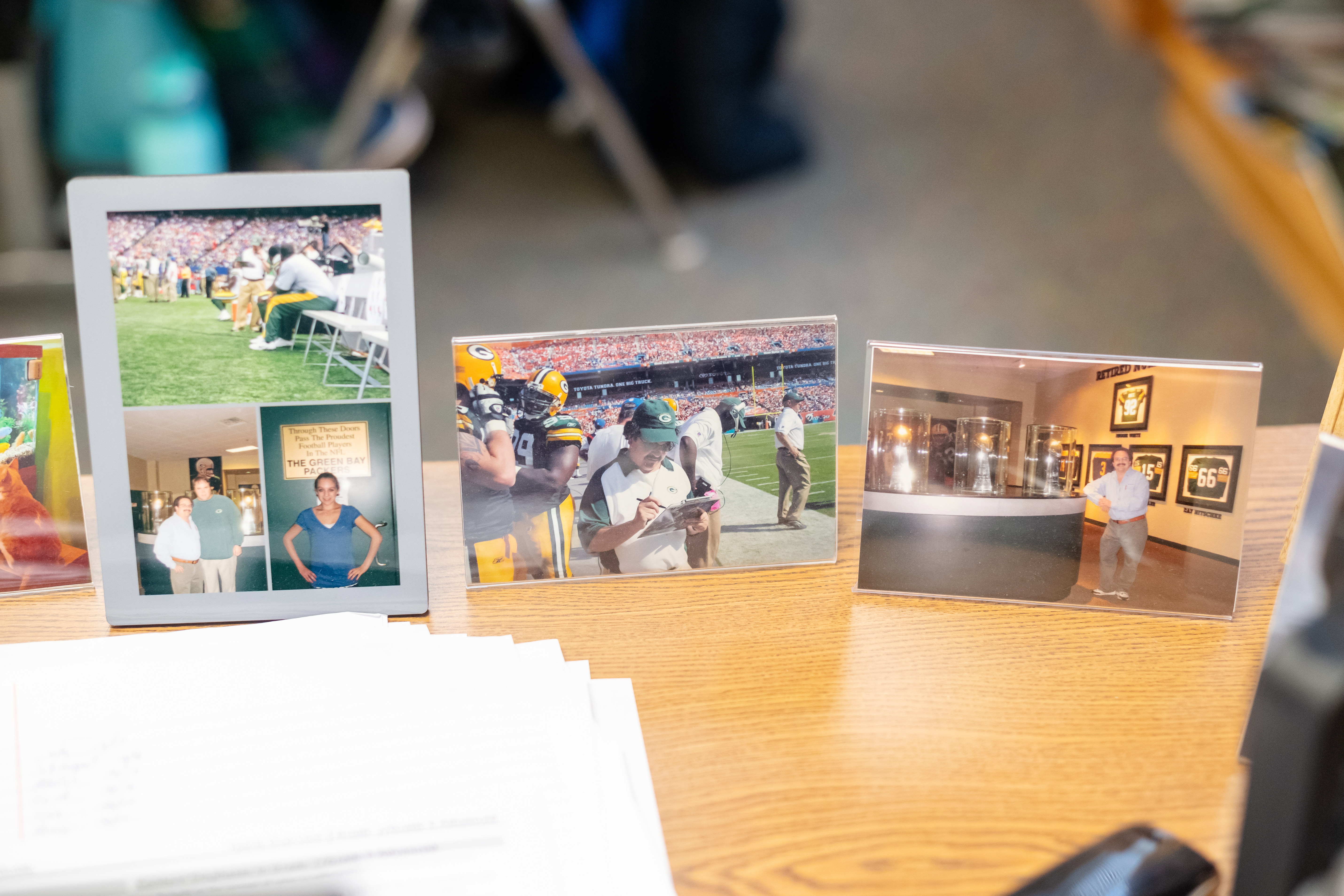 Malc displays pictures of his family -- and his time working with the Packers -- on his desk at Mantua Elementary.