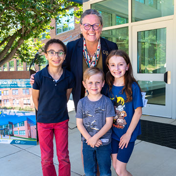 Reid in front of school with students