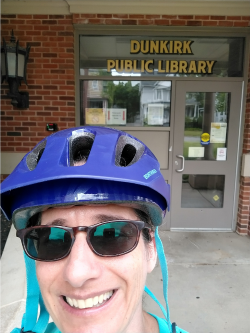 Teacher wearing a bike helmet outside a library