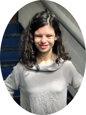 AT Ambassador, Sofia, is wearing a gray shirt and is standing in front of stairs