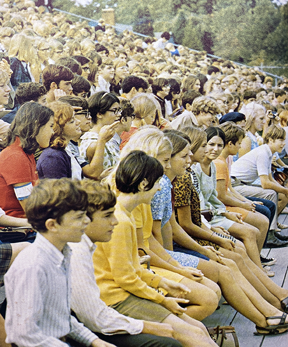 A yearbook photograph of students sitting on the bleachers in the school’s stadium.