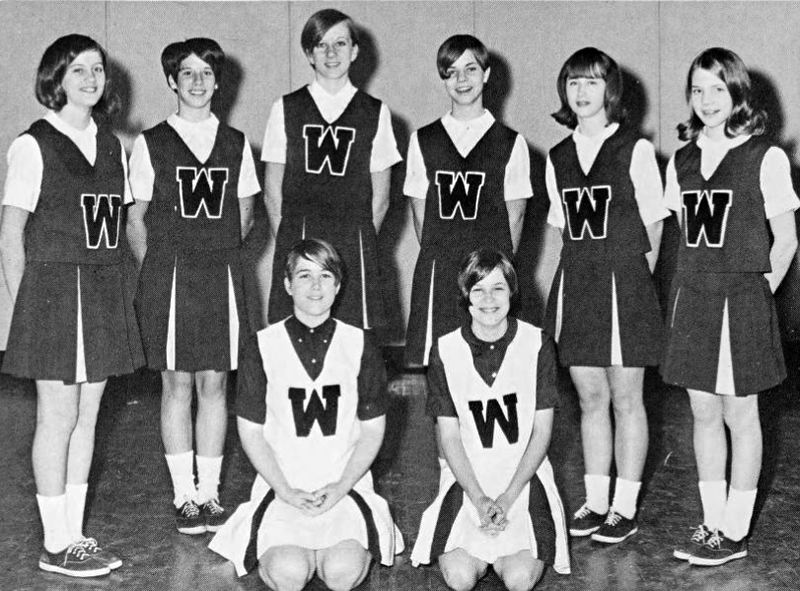 Black and white photograph showing students dressed in cheerleading uniforms.