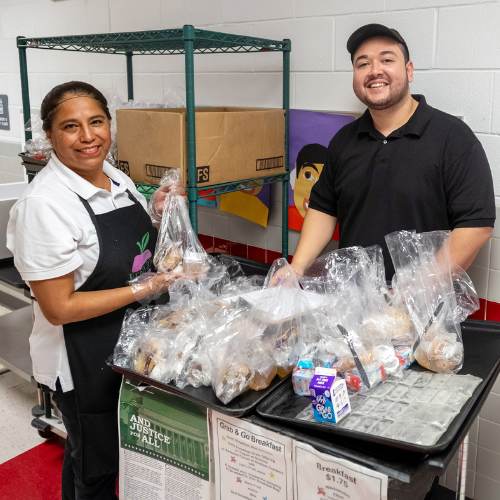 FNS team's Maria and Jack preparing breakfast for students at Beech Tree ES