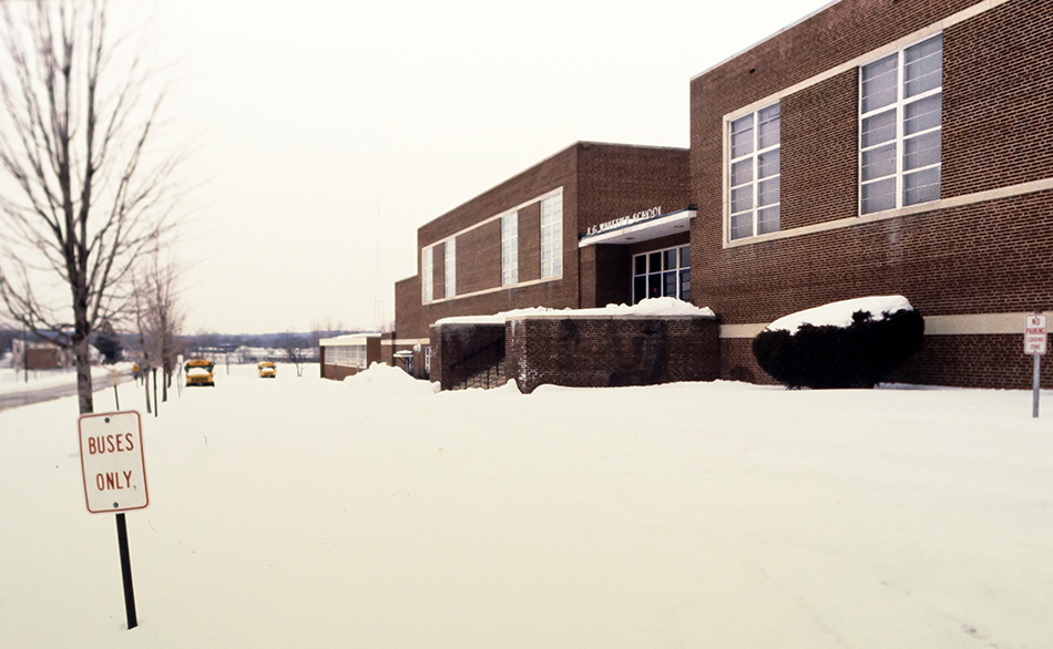 Photograph of the main entrance of Whittier Intermediate School at the school’s City of Falls Church location. The ground out front is covered in snow.