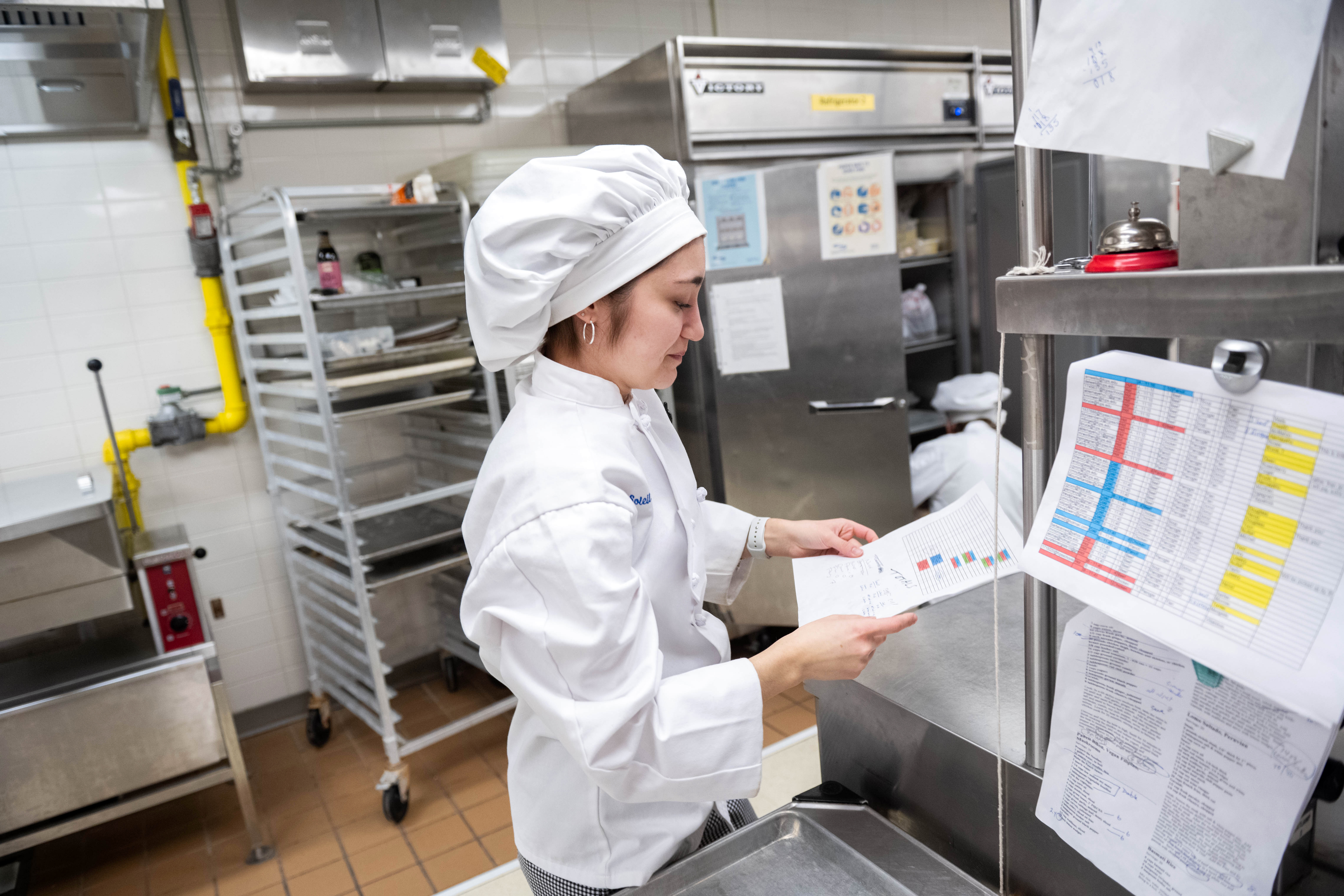 A student in the kitchen checks off the orders as they come in
