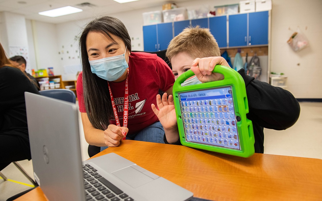 A student uses a device to communicate on a Zoom meeting. 