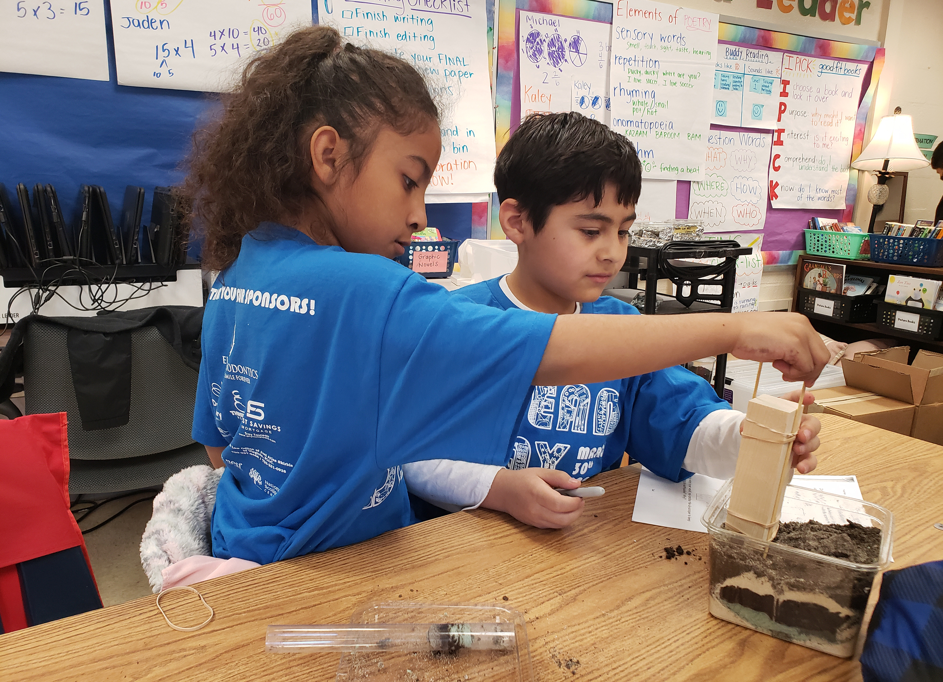 Two students test their sample landscape to see if it is a safe place to build their skyscraper.