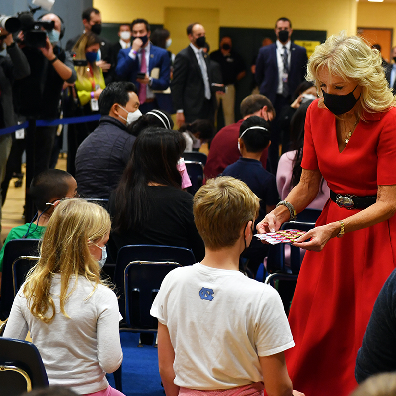 Dr. Jill Biden hands out stickers to children who have just been vaccinated.
