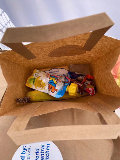 Volunteers pack improvised "Happy Meals" for kids, which include a toy with the bagged lunch.