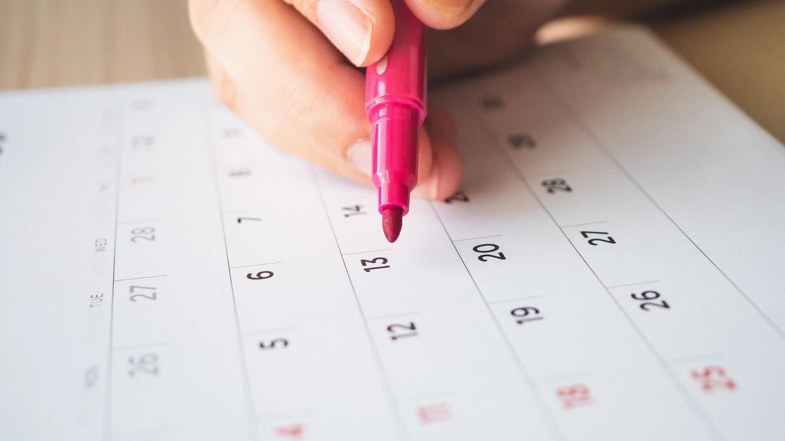 pen marking date on calendar