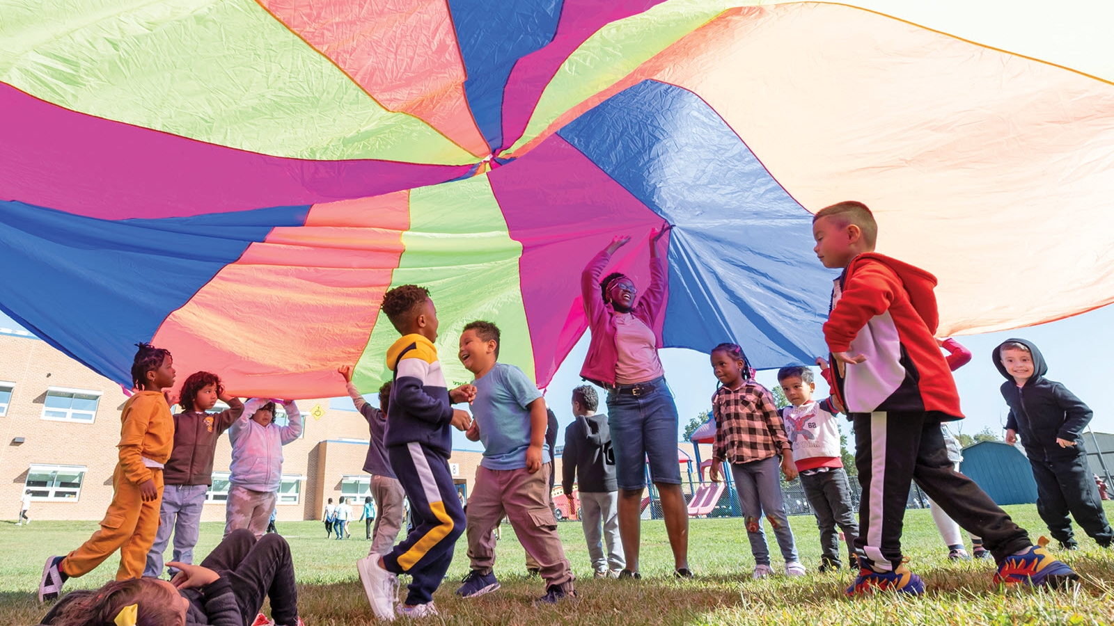 children playing outside with parachute
