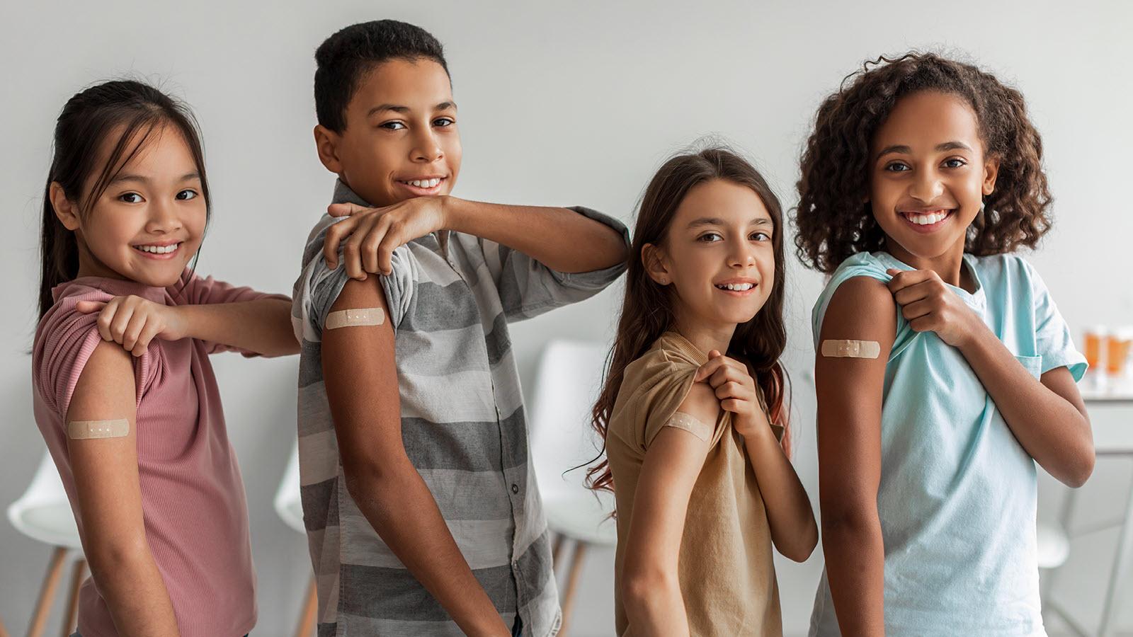 four students with bandaids on their arms